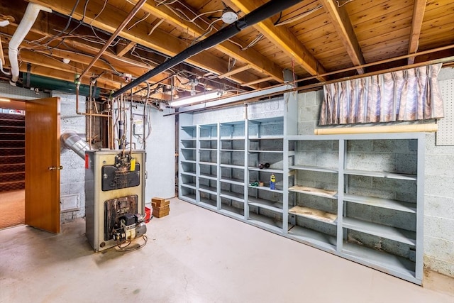 unfinished below grade area with a heating unit and stairway
