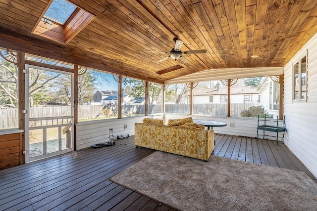 unfurnished sunroom with a ceiling fan and a skylight
