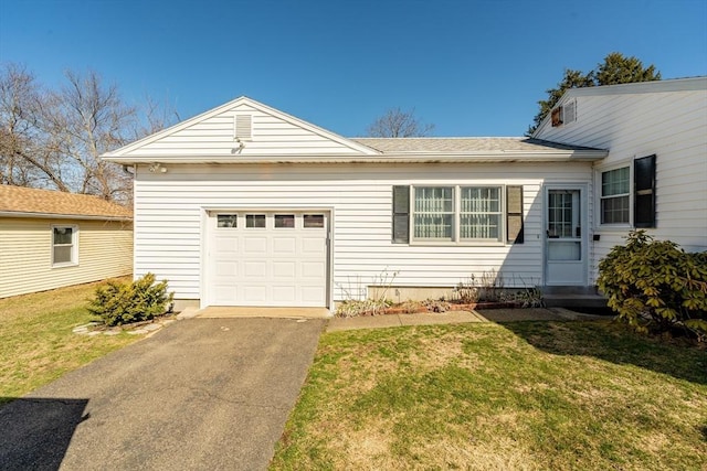 view of front of house featuring a front lawn, aphalt driveway, and an attached garage