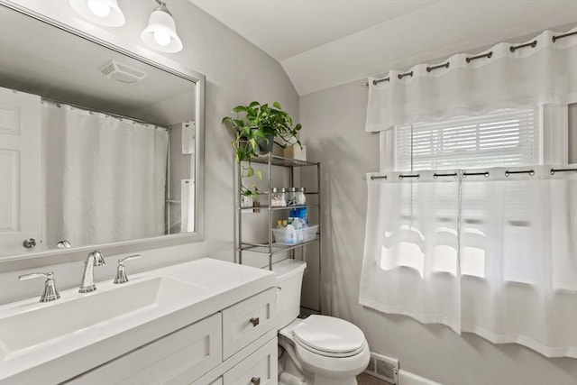 bathroom featuring visible vents, lofted ceiling, toilet, and vanity