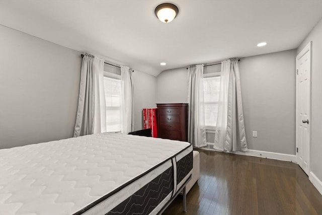 bedroom featuring dark wood finished floors, multiple windows, baseboards, and vaulted ceiling