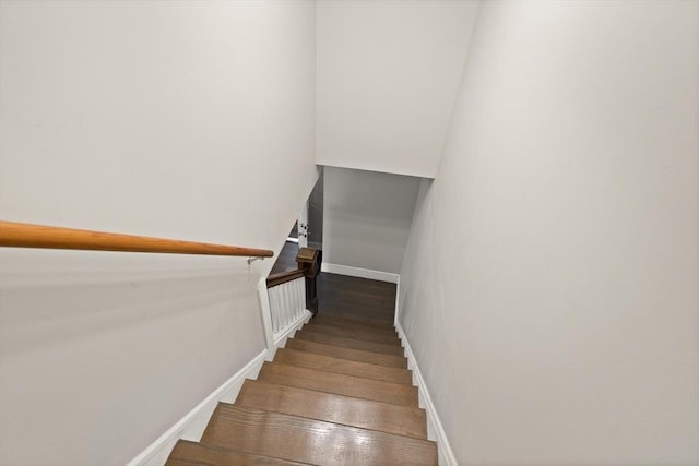 staircase featuring baseboards and hardwood / wood-style flooring