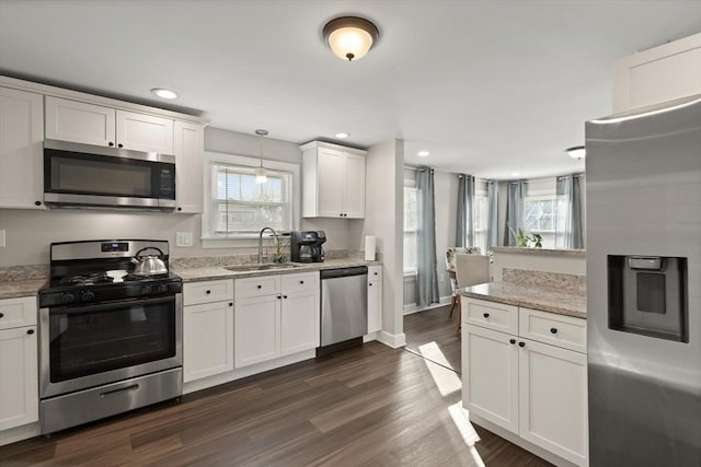 kitchen with recessed lighting, dark wood-style floors, white cabinets, stainless steel appliances, and a sink