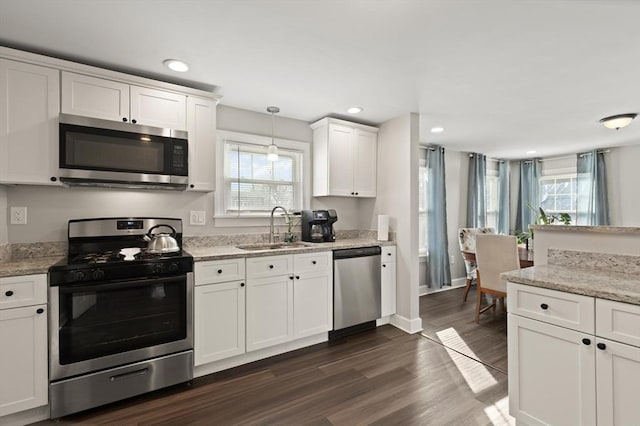 kitchen featuring dark wood finished floors, recessed lighting, white cabinets, stainless steel appliances, and a sink