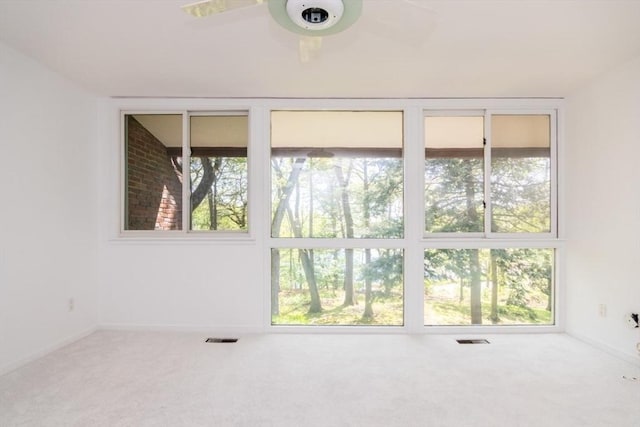 241 Perkins St Unit J602, Boston, MA 02130 - empty room featuring carpet flooring, healthy amount of natural light, a ceiling fan, and baseboards