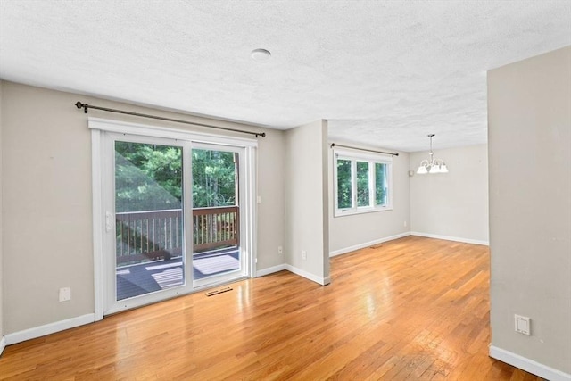 225 Lincoln St Unit G3, Duxbury, MA 02332 - empty room with a chandelier, light wood finished floors, and a textured ceiling