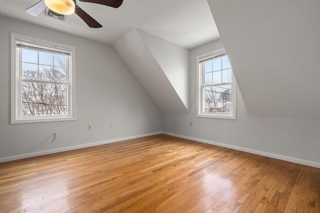 additional living space featuring vaulted ceiling, a healthy amount of sunlight, ceiling fan, and light hardwood / wood-style floors