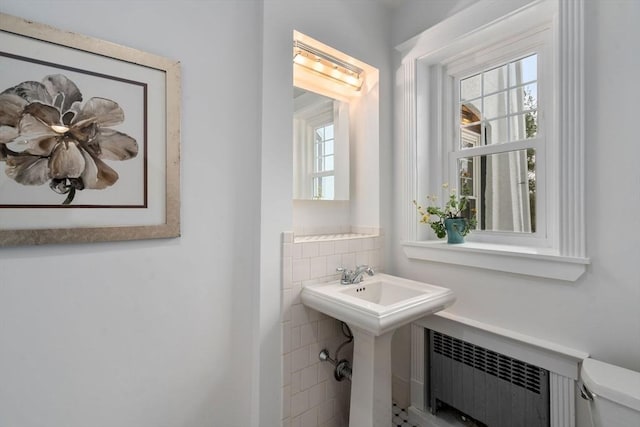 bathroom with radiator, toilet, and a sink