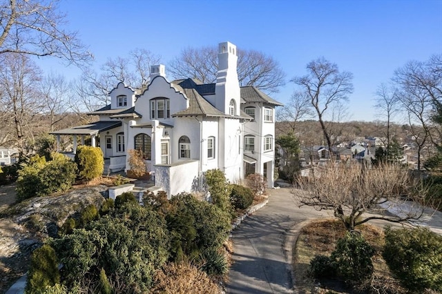 view of front of home with a chimney and stucco siding