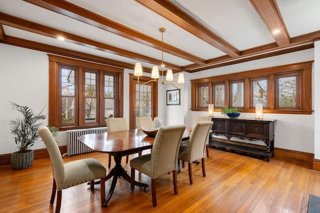 dining space featuring light wood-style flooring, baseboards, radiator, beamed ceiling, and an inviting chandelier