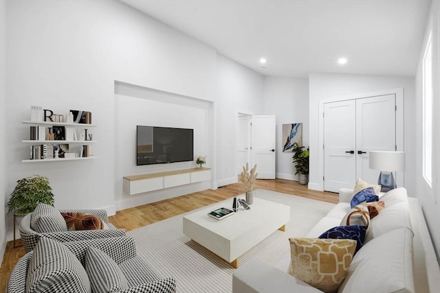 living room with hardwood / wood-style floors and lofted ceiling