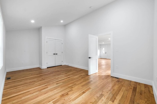 unfurnished room with lofted ceiling and light hardwood / wood-style flooring