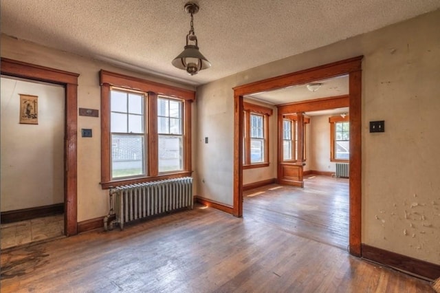 interior space featuring radiator heating unit, hardwood / wood-style floors, and a textured ceiling