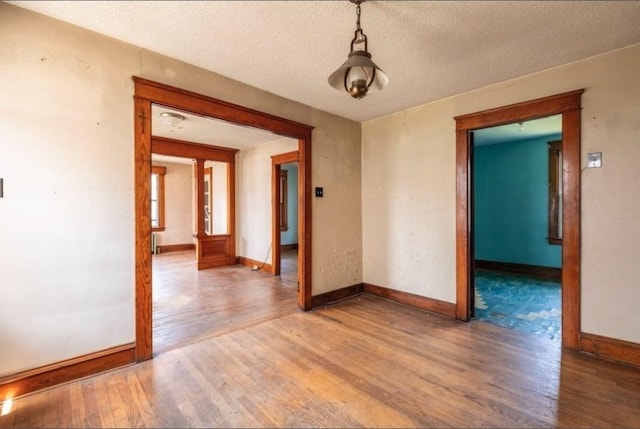 spare room featuring hardwood / wood-style floors and a textured ceiling