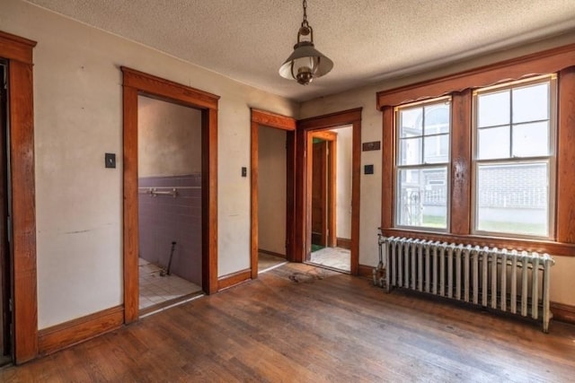 interior space featuring wood-type flooring, radiator heating unit, a closet, and a textured ceiling