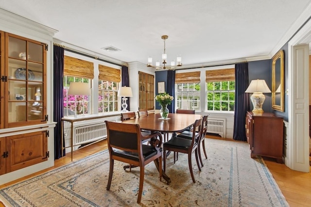 114 Chestnut St, North Reading, MA 01864 - dining area with radiator, a chandelier, light wood-style floors, and ornamental molding