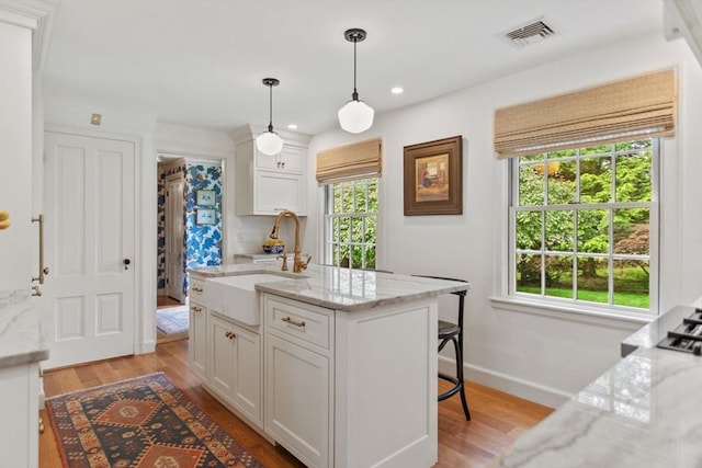 114 Chestnut St, North Reading, MA 01864 - kitchen with a sink, white cabinetry, light wood finished floors, decorative light fixtures, and recessed lighting