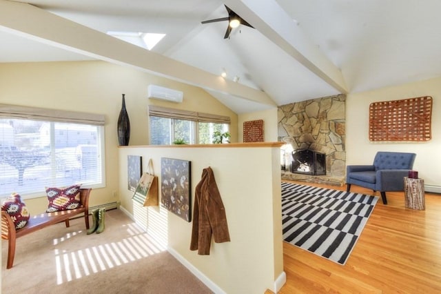 living area with a fireplace, lofted ceiling with skylight, and a wall unit AC