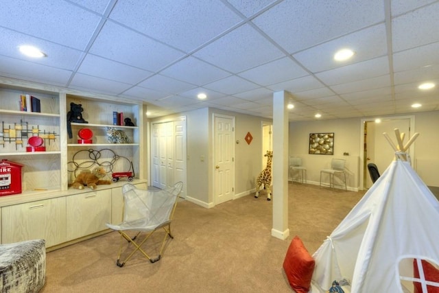 rec room featuring a paneled ceiling and light carpet