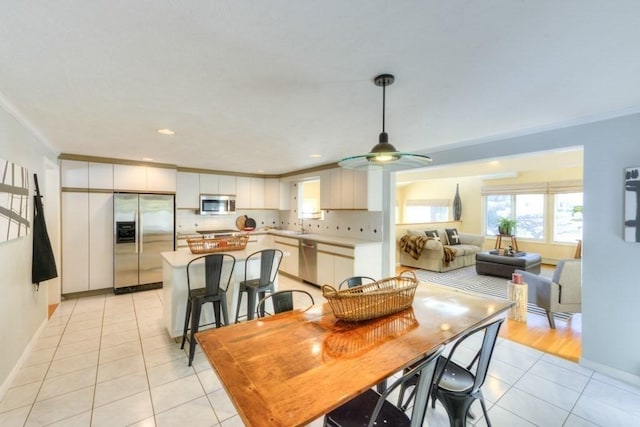 tiled dining room featuring crown molding and sink