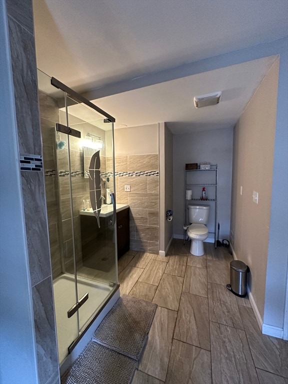 bathroom with toilet, walk in shower, and vanity