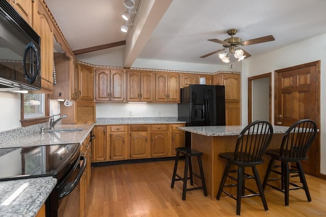 20 Blaine Ave, Worcester, MA 01603 - kitchen featuring black appliances, brown cabinets, a breakfast bar, a ceiling fan, and vaulted ceiling