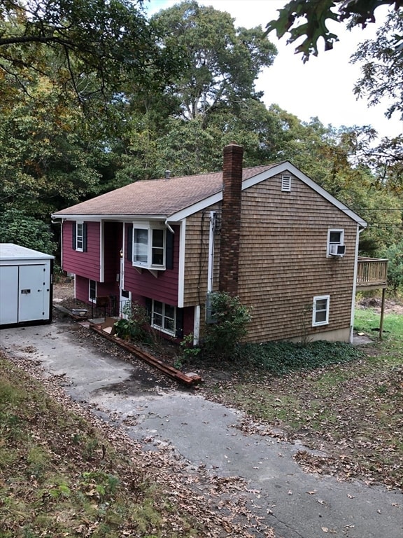 view of property exterior with a storage unit