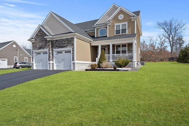 view of front of property featuring stone siding, a porch, driveway, and a front lawn