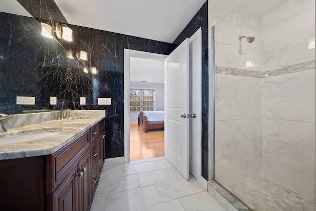 full bathroom featuring a sink, tiled shower, marble finish floor, and ensuite bathroom