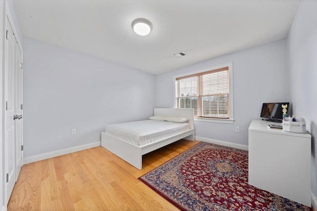 bedroom featuring baseboards, visible vents, and light wood-type flooring