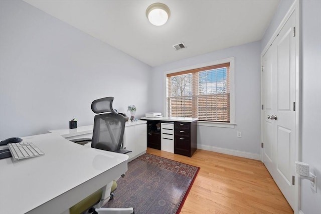 home office with baseboards, visible vents, and light wood-type flooring