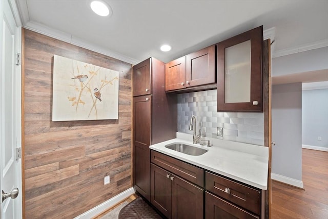 kitchen with baseboards, dark wood finished floors, light countertops, decorative backsplash, and a sink