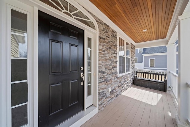 entrance to property featuring covered porch and stone siding