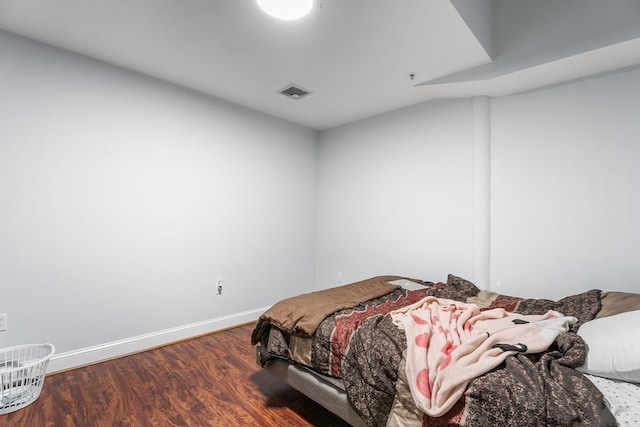 bedroom with hardwood / wood-style floors and lofted ceiling