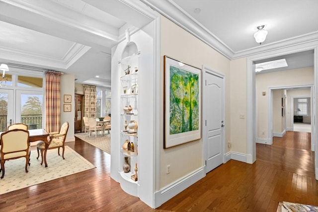 foyer with dark wood-type flooring and crown molding