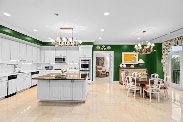 kitchen featuring a center island, a notable chandelier, white cabinetry, and stainless steel appliances