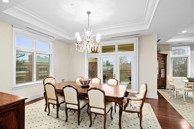 dining space with a tray ceiling, crown molding, and an inviting chandelier