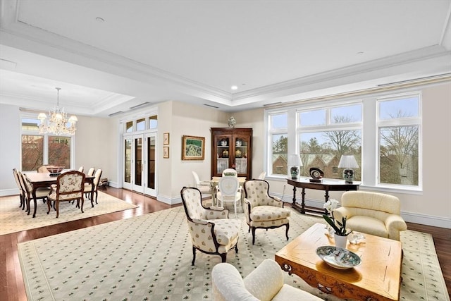 interior space with baseboards, an inviting chandelier, dark wood-style floors, crown molding, and a tray ceiling