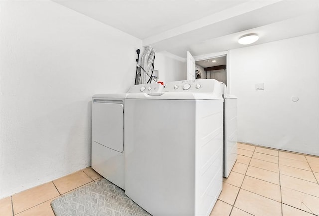 laundry room with washing machine and clothes dryer and light tile patterned floors