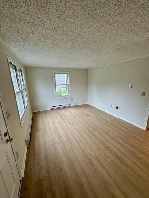 270 Sunderland St Unit 77, Worcester, MA 01604 - empty room with a baseboard heating unit, light wood-type flooring, baseboards, and a textured ceiling