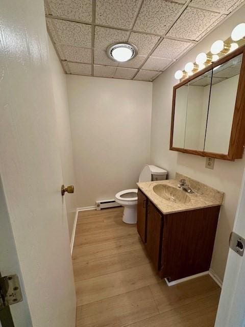 270 Sunderland St Unit 77, Worcester, MA 01604 - bathroom with a baseboard radiator, wood finished floors, vanity, toilet, and a drop ceiling