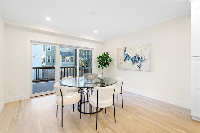 dining room featuring light wood-type flooring and crown molding