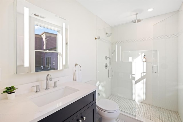 bathroom featuring vanity, toilet, and an enclosed shower