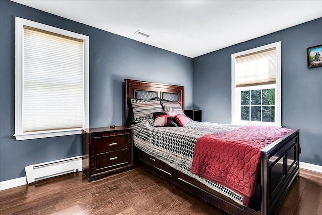 bedroom featuring dark wood-type flooring and a baseboard heating unit