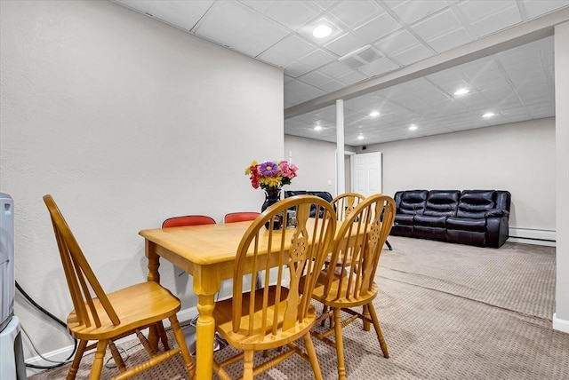 carpeted dining area with a baseboard heating unit