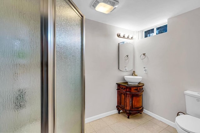 bathroom with a shower with shower door, vanity, tile patterned floors, and toilet