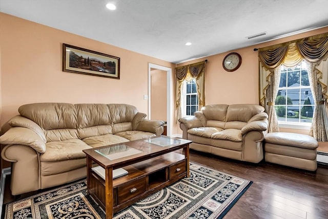 living room featuring a baseboard heating unit and dark hardwood / wood-style floors