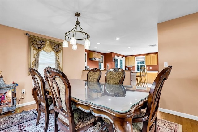 dining area with a wealth of natural light and hardwood / wood-style flooring