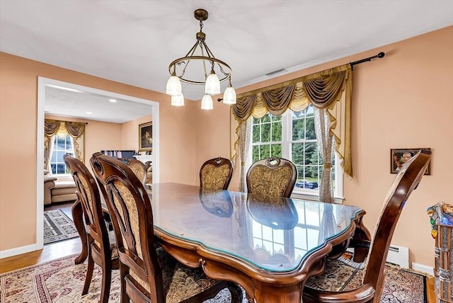 dining area featuring hardwood / wood-style flooring and a chandelier