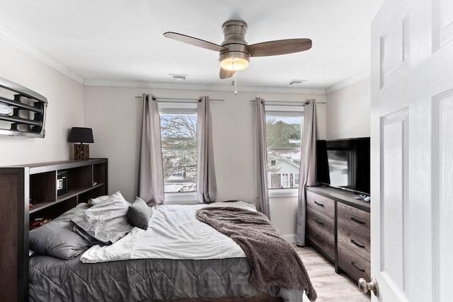 bedroom with ceiling fan, ornamental molding, and light hardwood / wood-style flooring